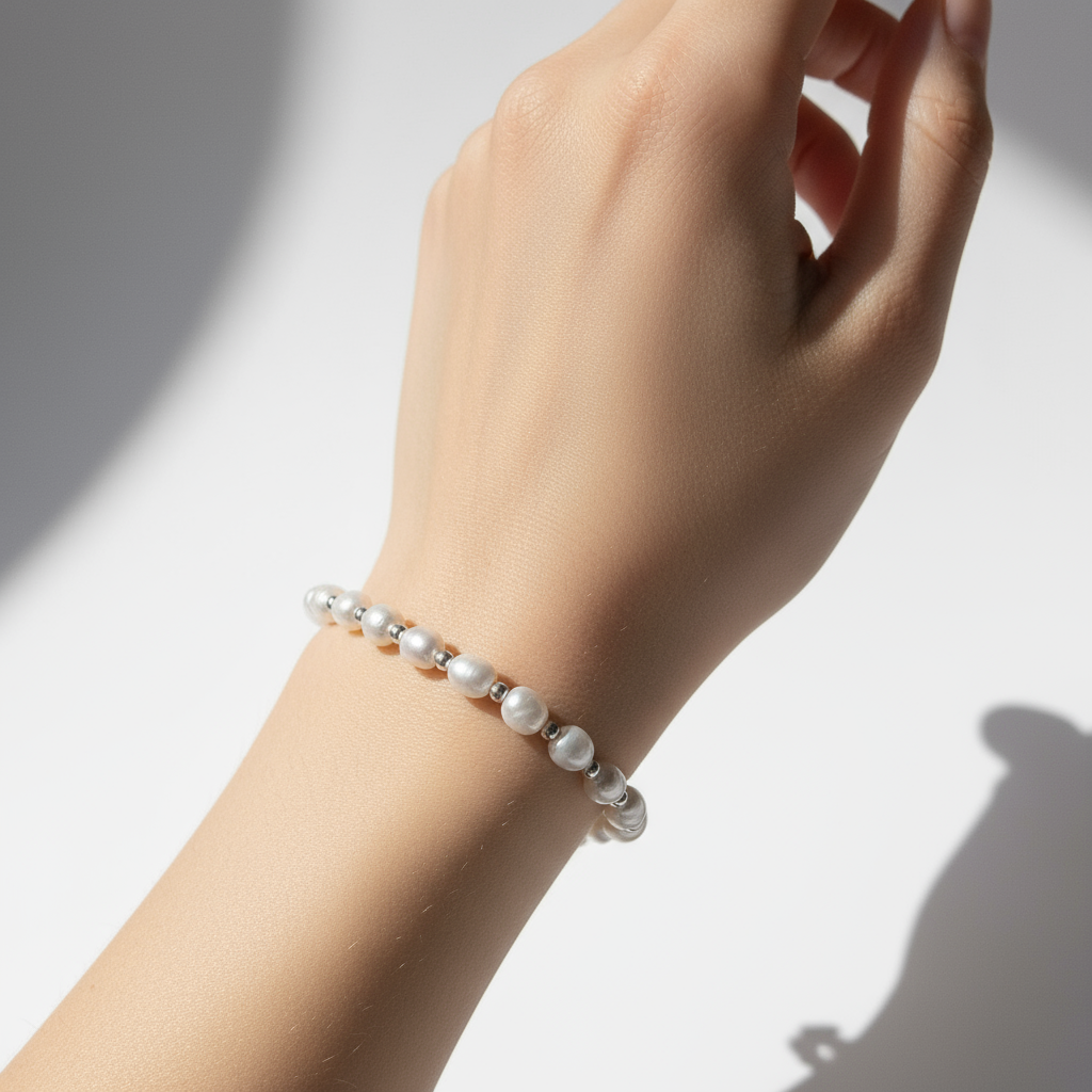 진주 팔찌를 착용한 여성의 손